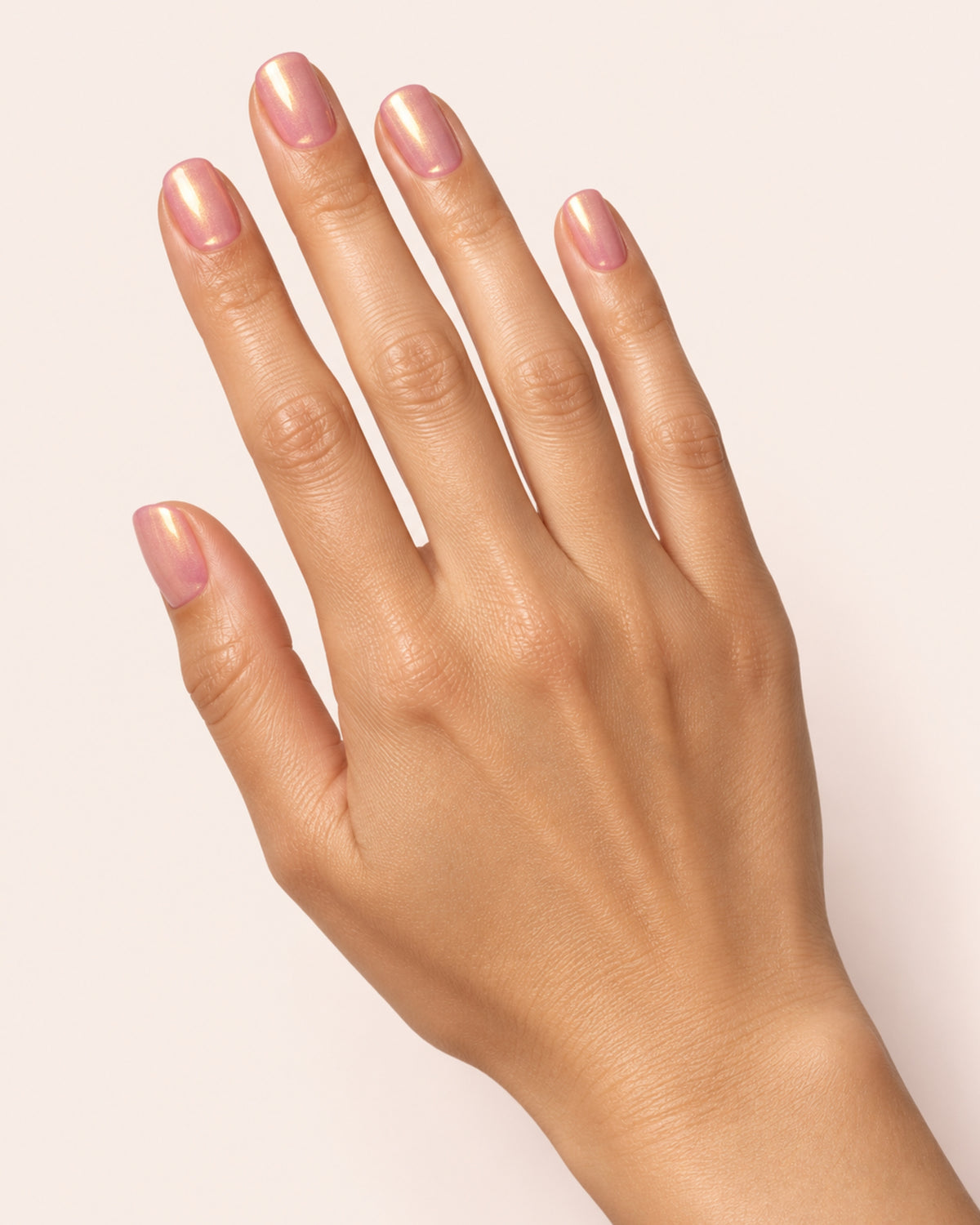 Mayvee nail polish in 'The Stars Were Right' pink and gold shimmer nail colour on olive skin tone