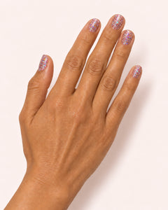 Mayvee nail polish in 'Cancel My Plans' pink holographic glitter nail colour on medium skin tone