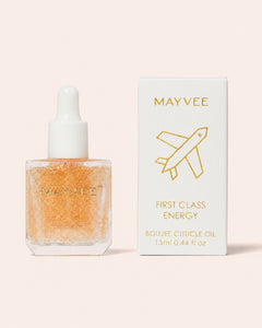 mayvee cuticle oil in a bottle with gold flecks and white dropper and a white box beside and a light peach background